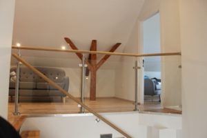 Glazen balustrade binnenshuis met houten leuning